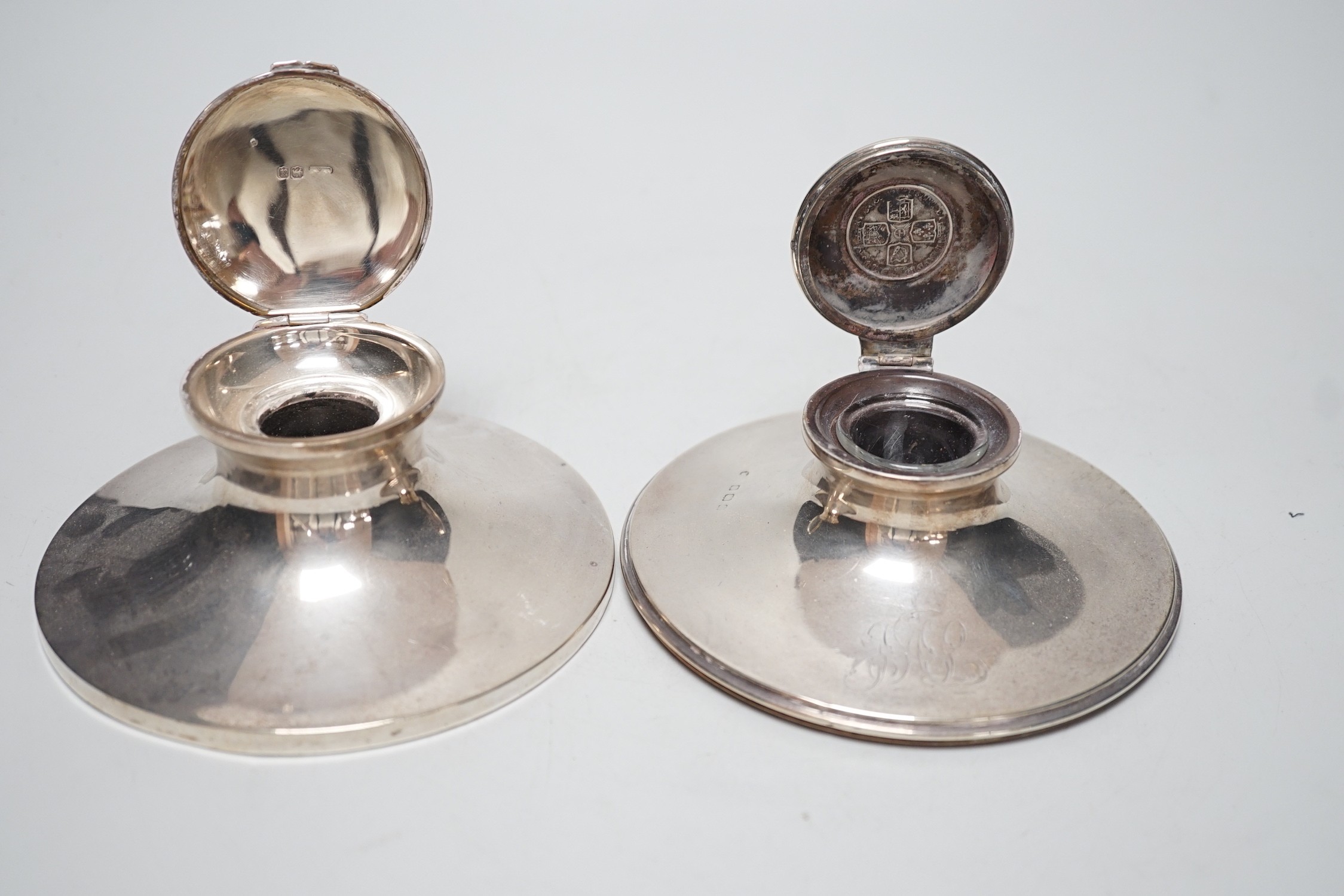 A George V silver mounted capstan inkwell, by Mappin & Webb, London, 1916, diameter 13.6cm and one other silver mounted capstan inkwell.